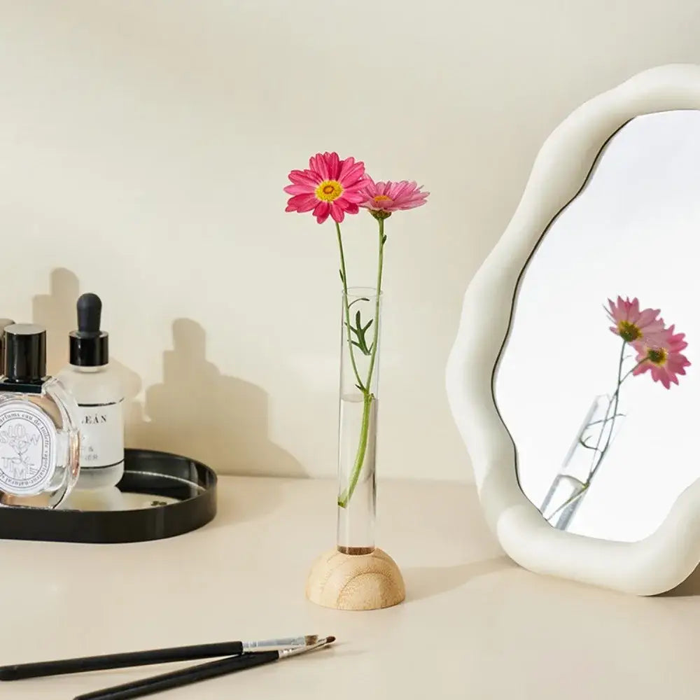 DecorBites clear plastic test tube vase with wooden base holding two pink daisies for home decor