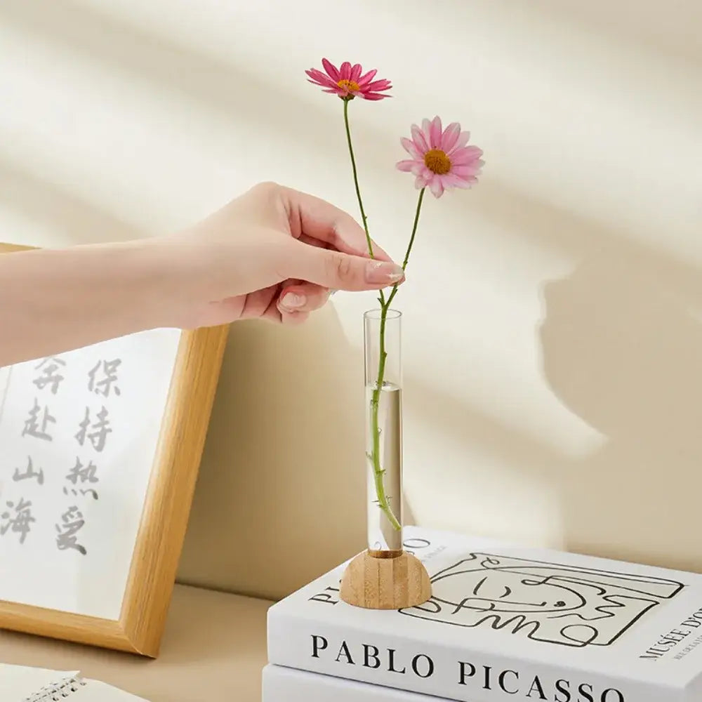 DecorBites clear vase with bamboo base holding two pink daisies as a hydroponic vase tabletop decoration