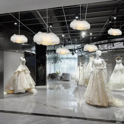 Elegant ivory wedding gown with intricate lace and tiered skirt displayed near a decorbites cloud chandelier silk cotton lamp