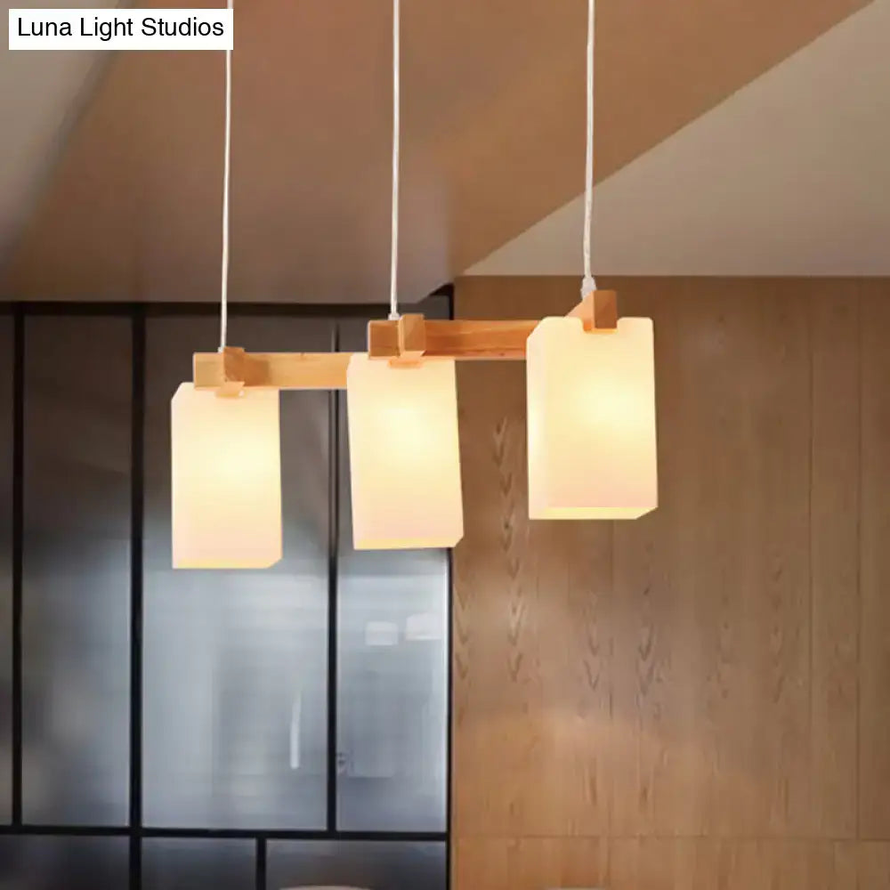 Decorbites cluster pendant kitchen lamp with three white glass shades and natural wood bar in modern design