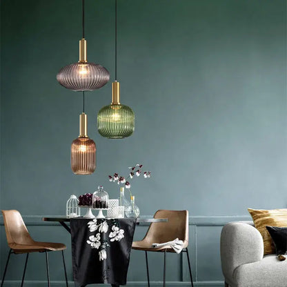 Three colorful glass pendant lights with ribbed translucent bodies in purple green and amber by DecorBites™ for retro style