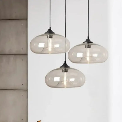 Three modern pendant lights with translucent gray glass shades and black metal fixtures for colorful LED decor