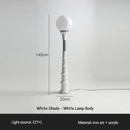 A sleek white decorbites colorful memphis floor lamp with a spherical glass shade and tiered acrylic base crafted from iron art and acrylic