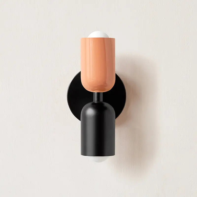 Coral-colored ceramic glass shade modern wall sconce with black metal base and circular backplate by decorbites