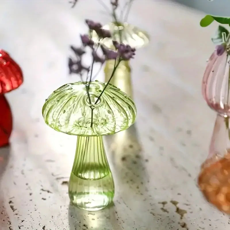 Translucent green glass colorful mushroom vase with ribbed stem and dotted cap holding delicate purple flowers