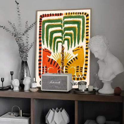 A vintage-style white Marshall speaker with silver accents on a shelf complements colorful tiger and leopard vintage poster wall art