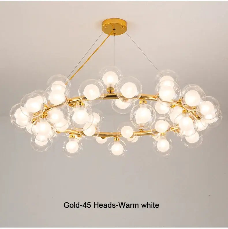 Gold-toned decorbites™ chandelier with 45 clear white glass balls emitting warm white light in black and gold design