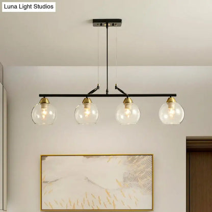 Black metal bar pendant light with four clear prismatic glass globe shades and brass accents for dining hall use