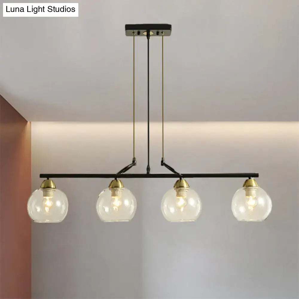 Black metal pendant light with four clear prismatic glass globes and brass accents for dining hall lighting