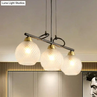 Decorbites contemporary black three-light pendant fixture with frosted globes and brass accents for dining hall with prismatic glass