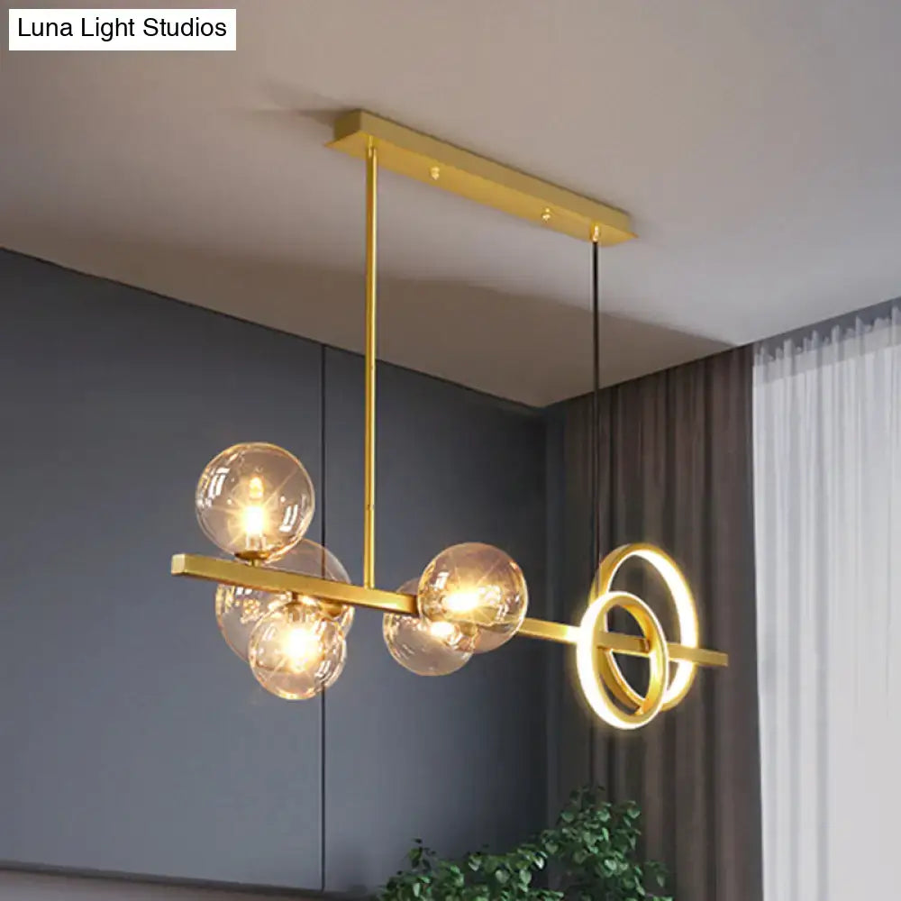 Gold-toned DecorBites™ contemporary glass island lamp with spherical milk white bulbs and circular ring accents for dining room