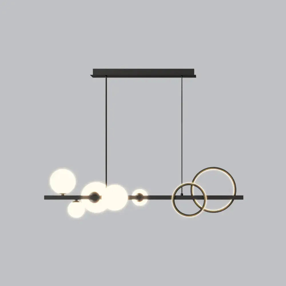Modern black metal island lamp with glowing spherical milk white bulbs and intersecting circular smoke grey rings for dining room