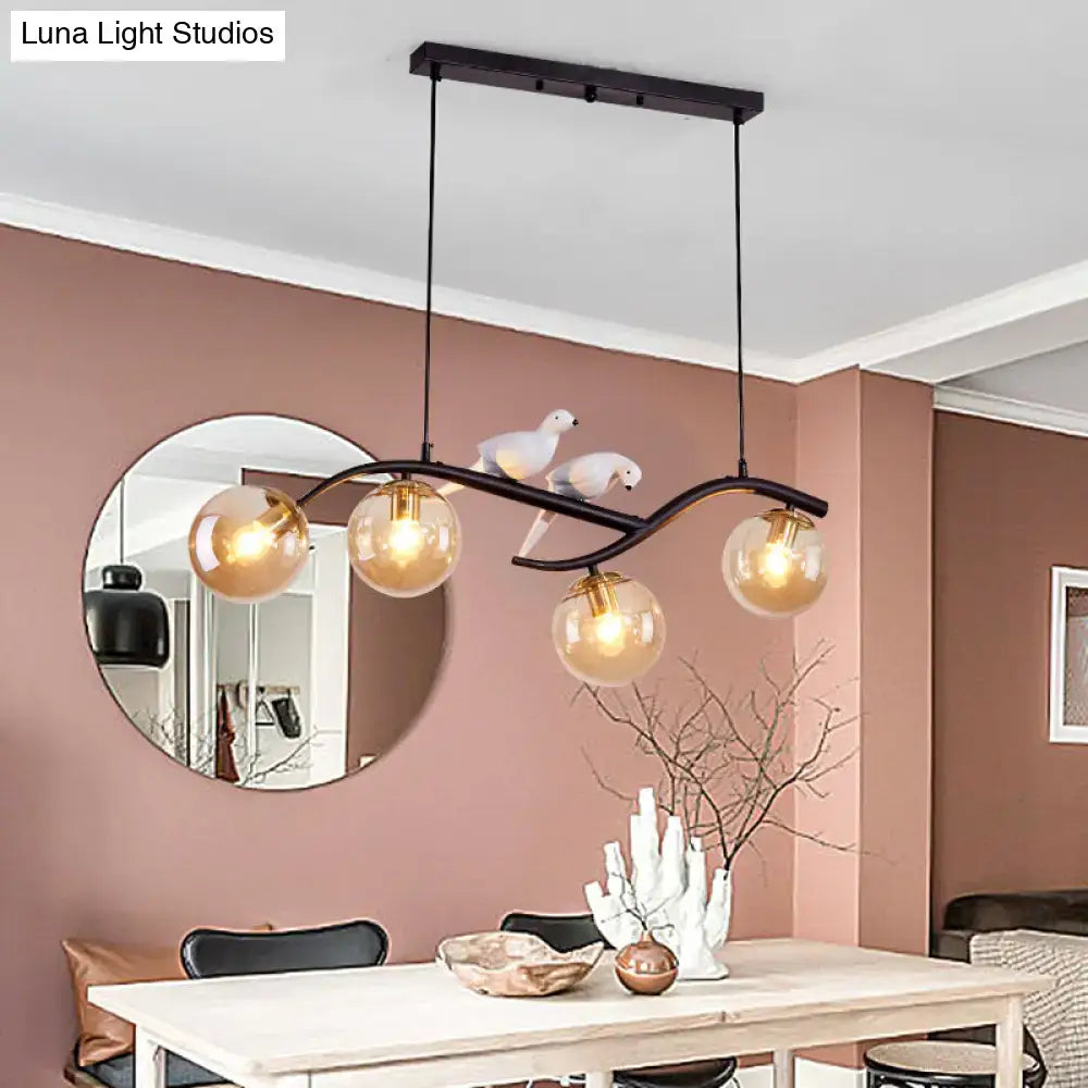 Black wrought iron decorbites contemporary 4-light pendant lamp with amber globes and decorative white birds smoke grey cognac