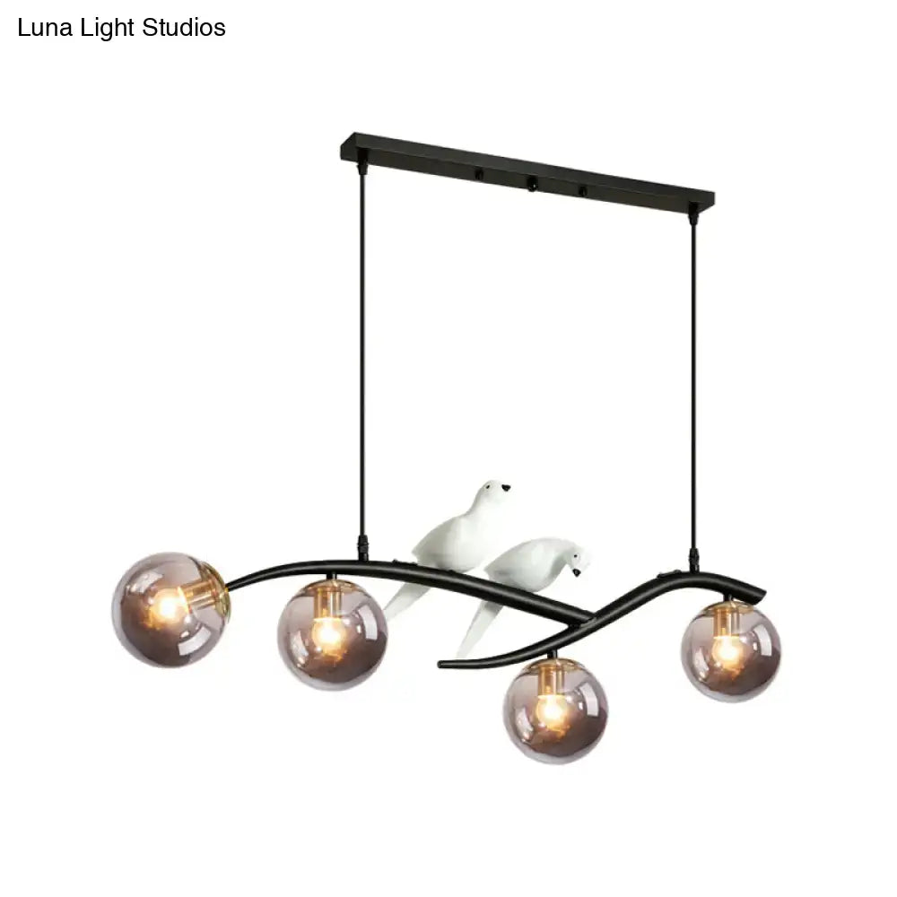 Black metal chandelier with smoke grey cognac glass shades and white ceramic bird decor for contemporary island lighting