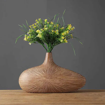 A sleek light brown contemporary resin vase by decorbites with a sunburst pattern for flower arrangements