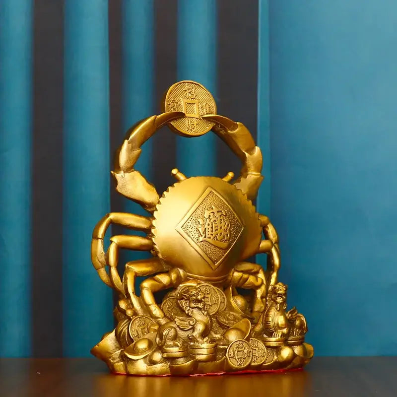 Golden metallic copper crab ornament with intricate carvings holding a coin surrounded by stacked coins and mythical creatures