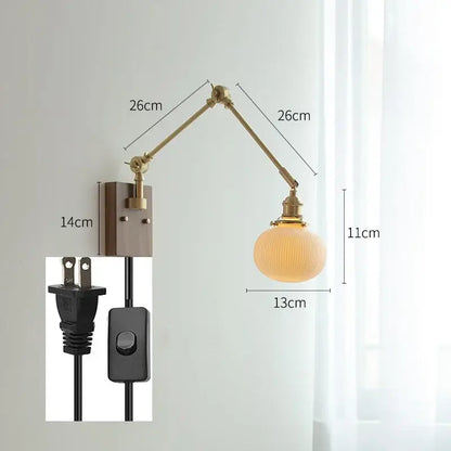 Brass-finished decorbites copper swing arm wall lamp with adjustable arm and ribbed frosted glass globe for bedroom use