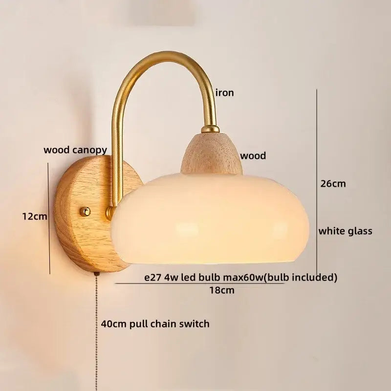 A warm-toned decorbites cotton led wall lamp with brass iron arm wooden base and opaque white glass shade for bedrooms