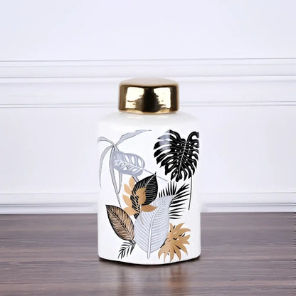 White ceramic jar with gold lid and tropical leaf decals for dining room decor by decorbites country ceramic
