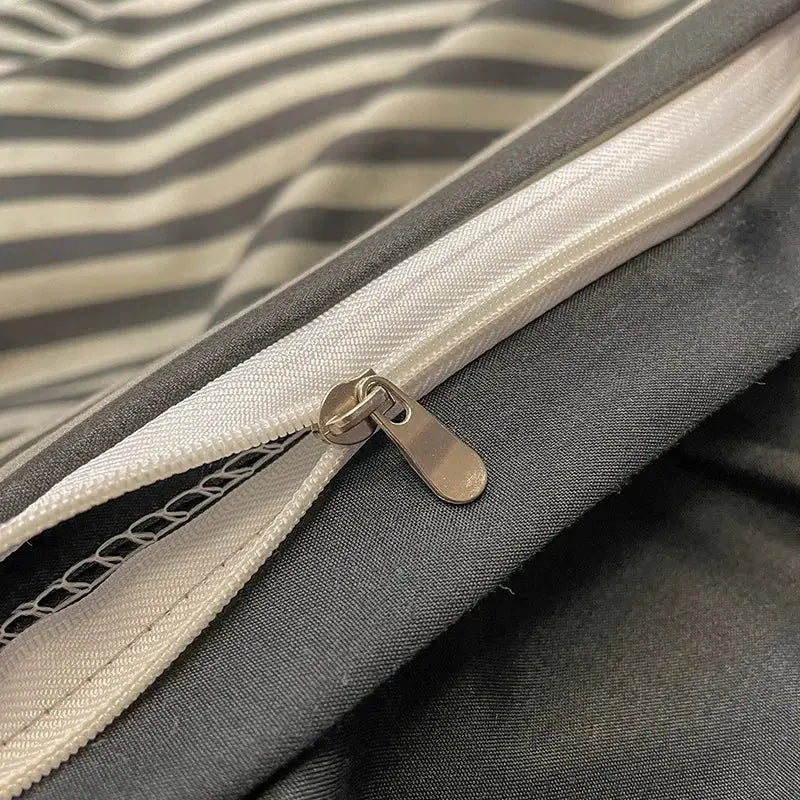 A silver-toned zipper with metallic pull tab on the seam of a light green nordic plaid 1pc duvet cover from decorbites