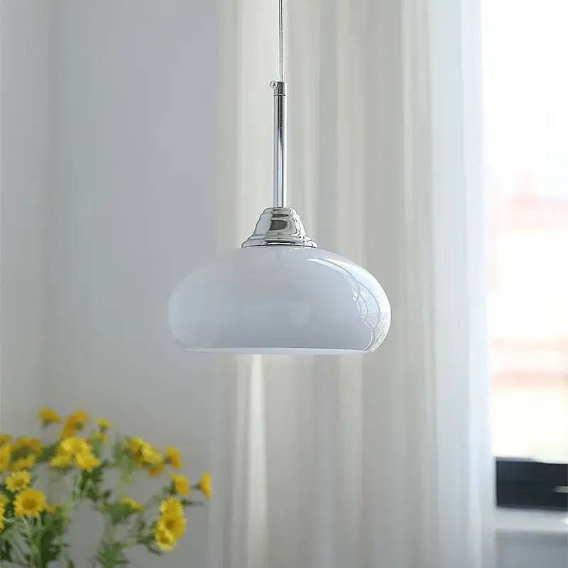 A sleek decorbites cream glass pendant light with polished chrome stem for dining room use in nordic style