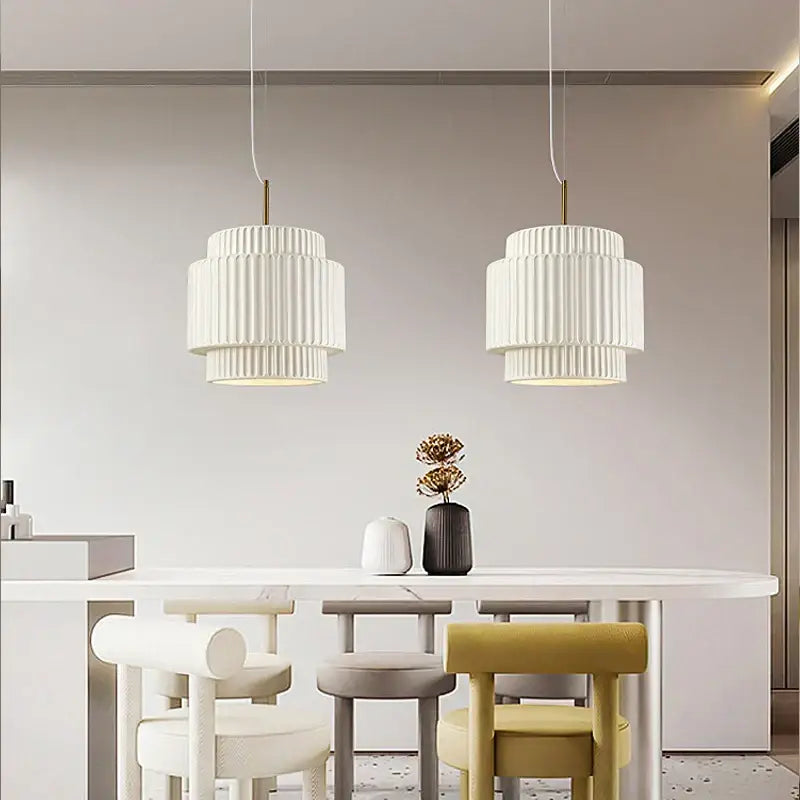 Two elegant cream wind led fluted pendant lights with vertical ridges and gold-toned stems in dining room chandelier