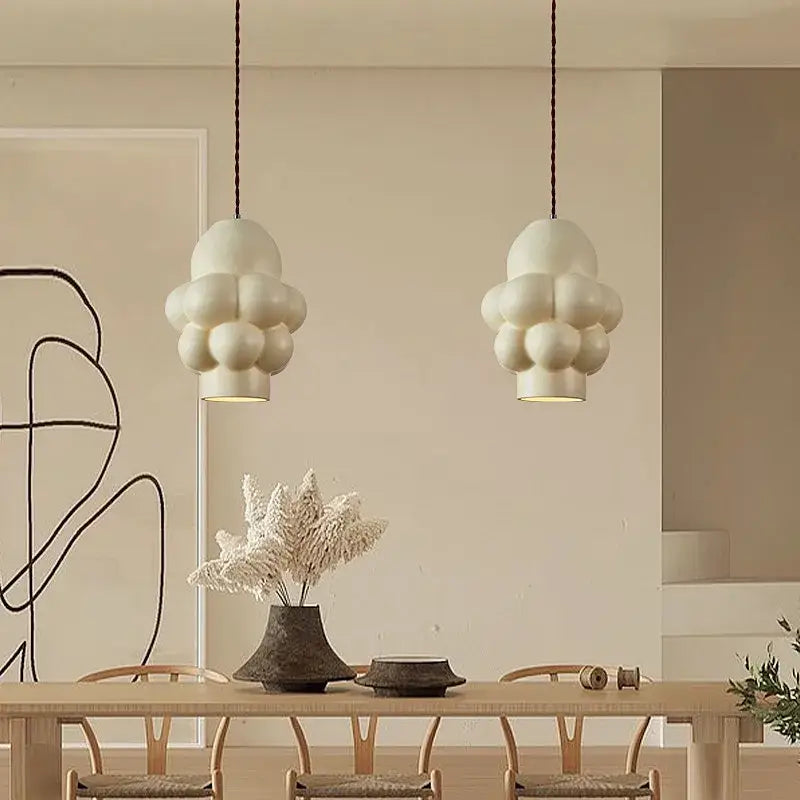 Off-white creamy wind led cloud pendant lights with matte finish hang from dark cords for dining room by decorbites