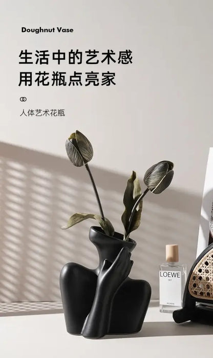 Black matte ceramic human vase in doughnut shape with sculpted form for minimalist home decor by DecorBites™