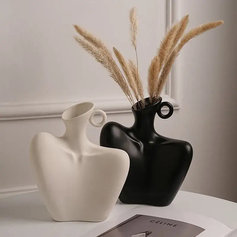 Two sculptural ceramic human vases in matte white and glossy black with circular neck handles for home decor