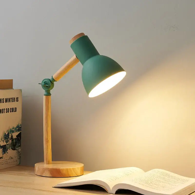 Teal creative nordic table lamp with wooden base and articulated arm casting warm light over an open book