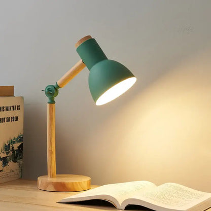 A teal creative nordic table lamp with wooden base and articulated arm casting warm light over open book
