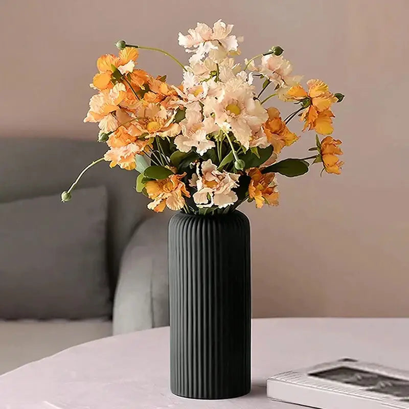 DecorBites™ creative striped black ribbed plastic flower vase holding orange and cream artificial floral arrangements