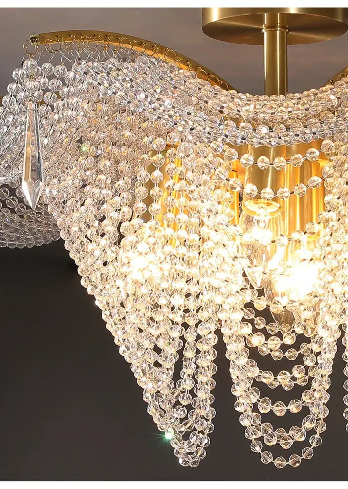 A decorbites crystal butterfly gold tassel chandelier with clear faceted beads and polished brass frame for living rooms