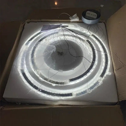 Decorbites crystal ceiling chandelier with concentric led rings and black accents in protective plastic wrap for indoor use