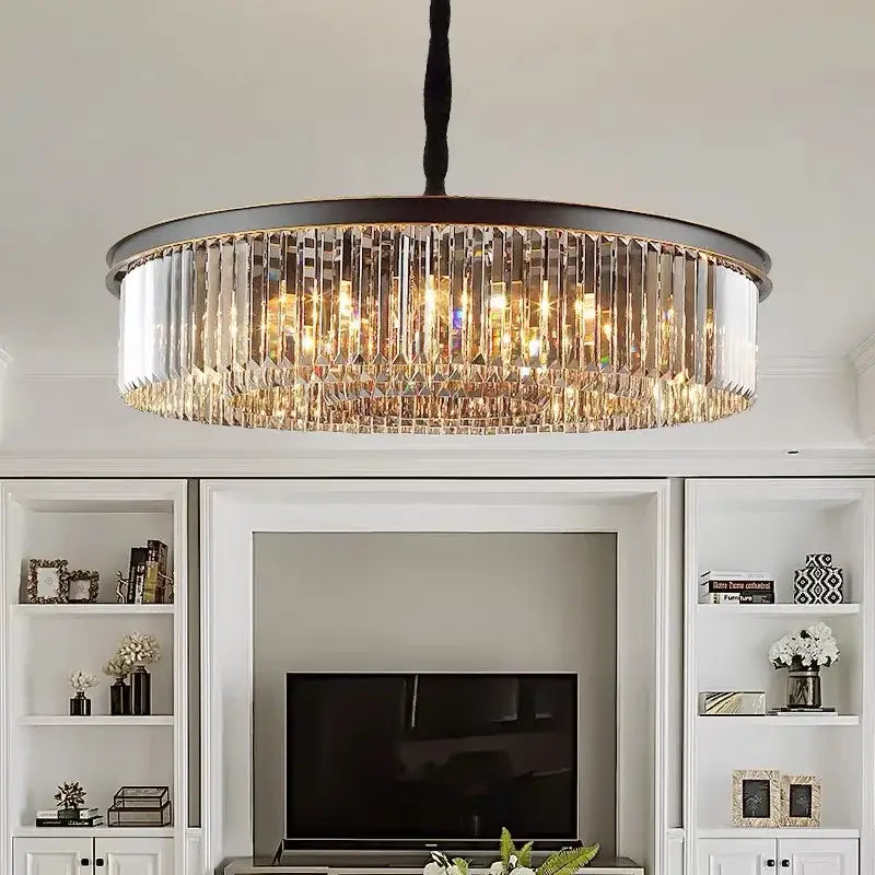 A decorbites crystal ceiling chandelier with dark metal frame and cascading clear crystal prisms emitting warm light