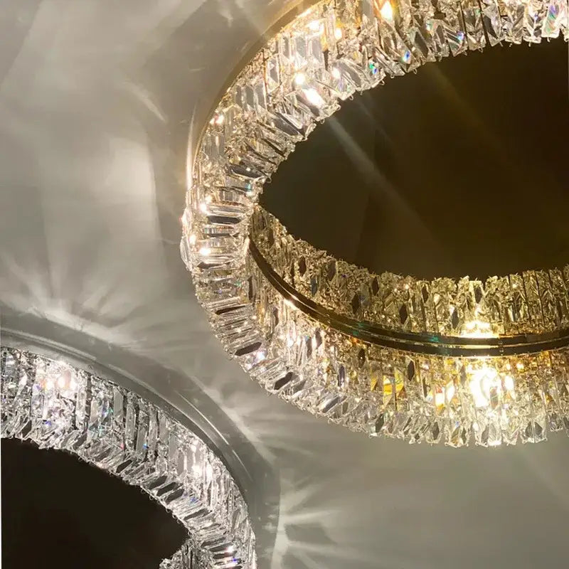 A decorbites crystal ceiling lamp featuring two golden concentric rings with faceted clear crystals for luxe lighting