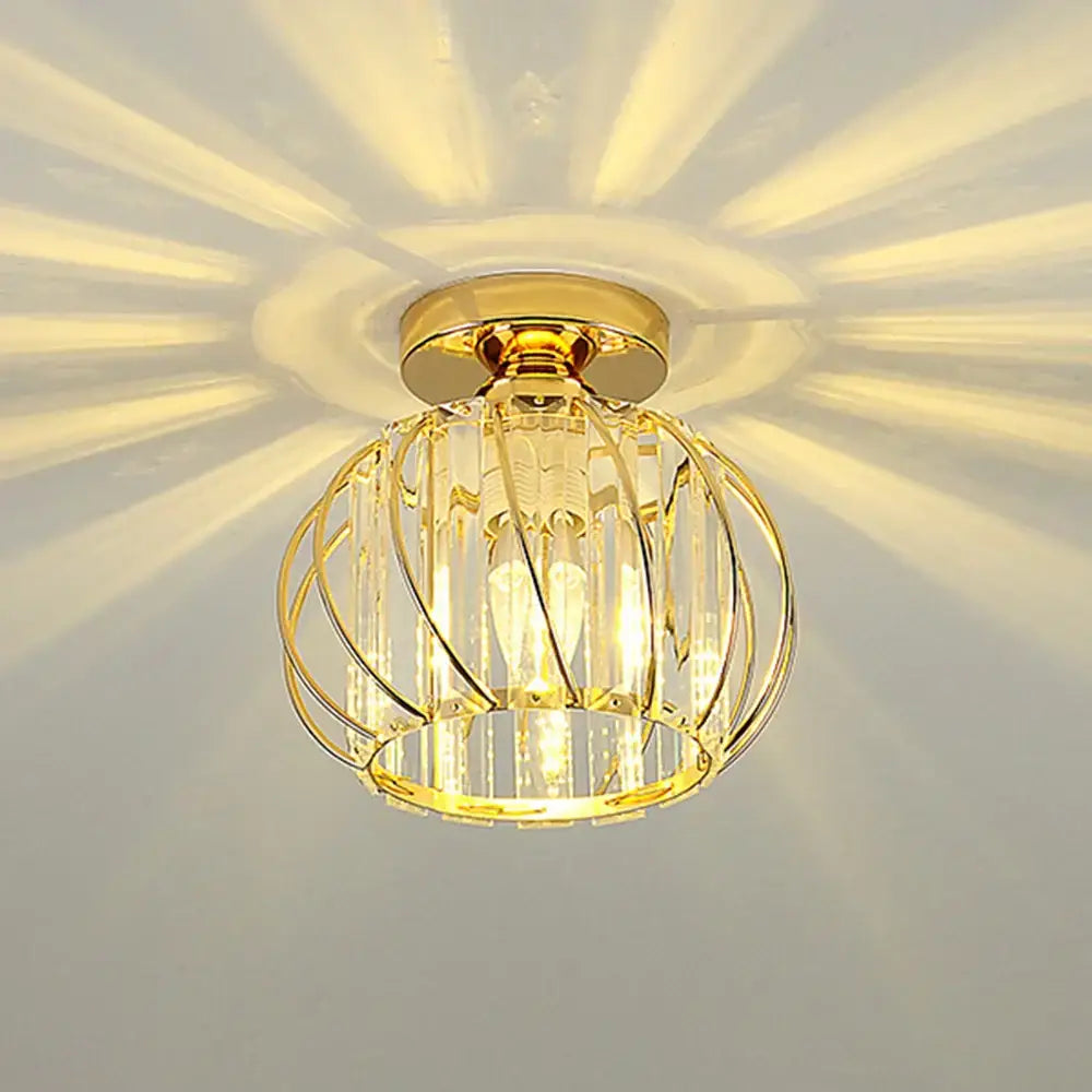 Decorbites crystal ceiling lamp gold-toned spherical cage design with metallic rods and clear prisms emitting warm light