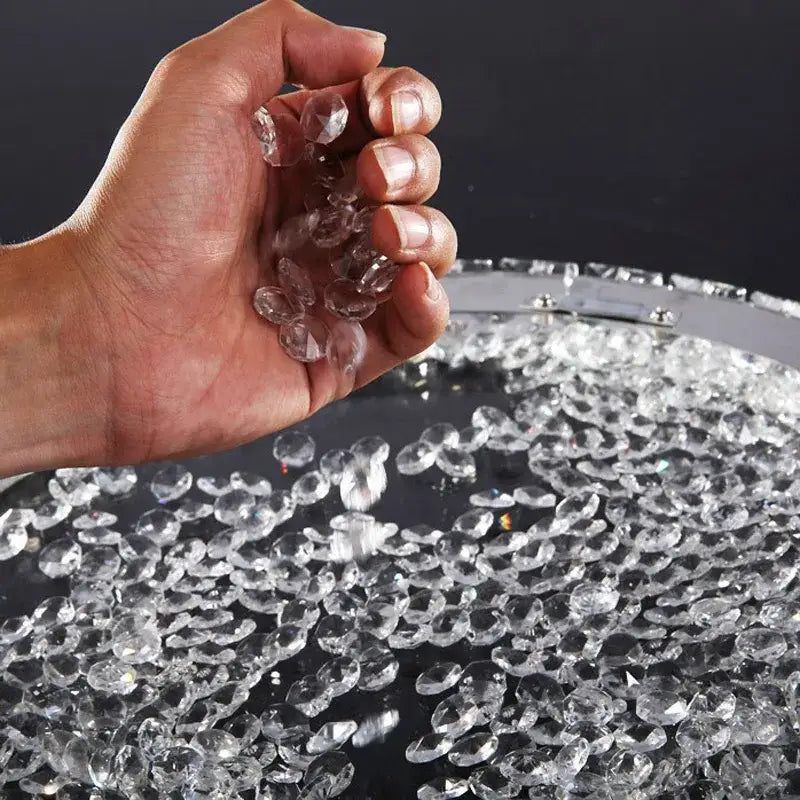 Hand holding clear faceted crystal beads from decorbites crystal ceiling light with LED bulbs for living room use