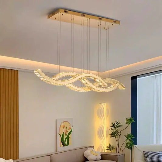 Gold-toned rectangular decorbites crystal chandelier pendant light with flowing crystals emitting warm ambient light