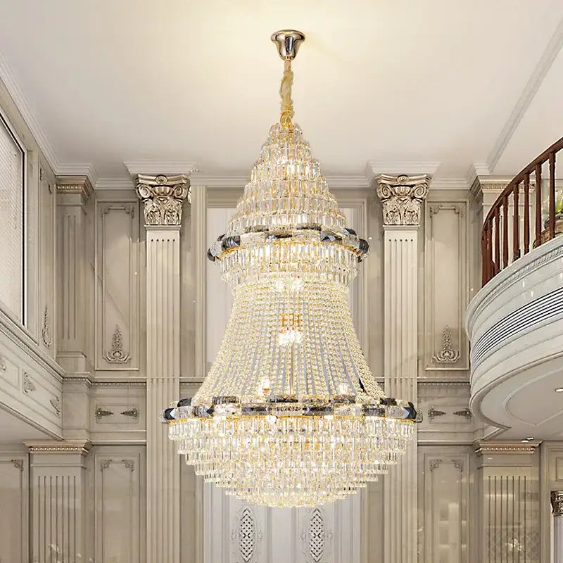 A multi-tiered decorbites crystal chandelier with gold-toned metal and cascading clear and darkened crystals for luxury lighting