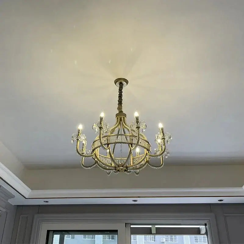 A gold-toned decorbites crystal chandelier with crystal accents and lit bulbs for living and dining rooms