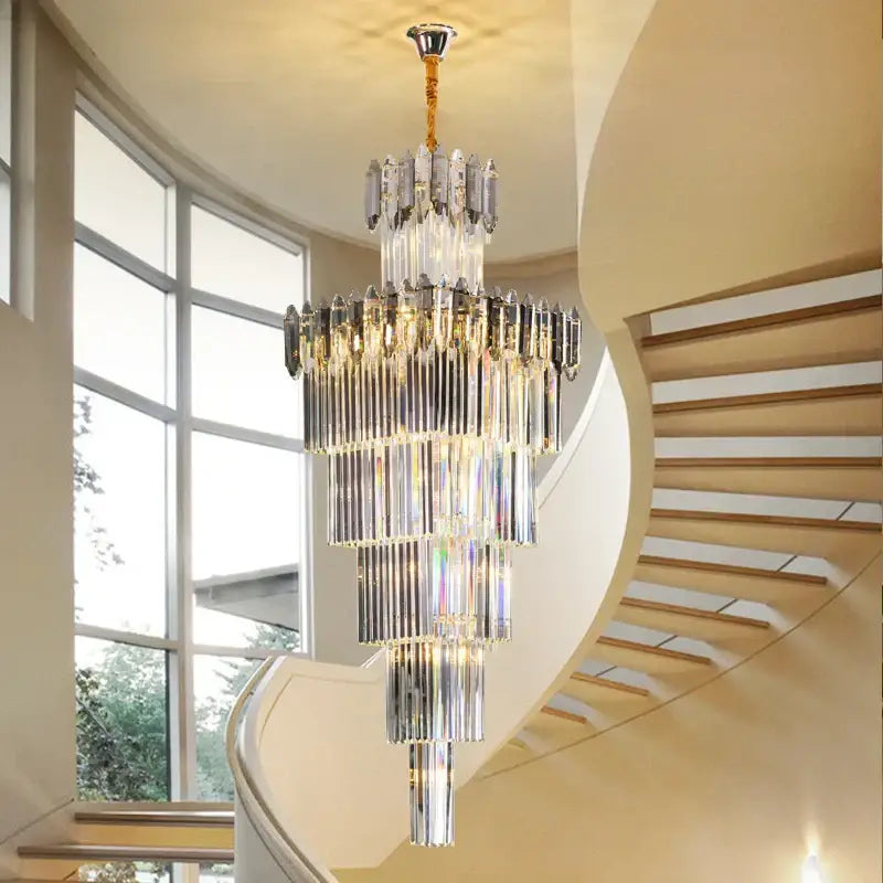 A multi-tiered decorbites crystal chandelier with cascading clear and smoky glass rods suspended by a gold chain