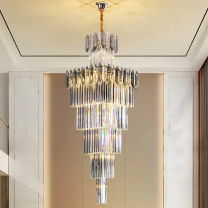A multi-tiered decorbites crystal chandelier with cascading clear and frosted glass rods and gold-toned chain suspension