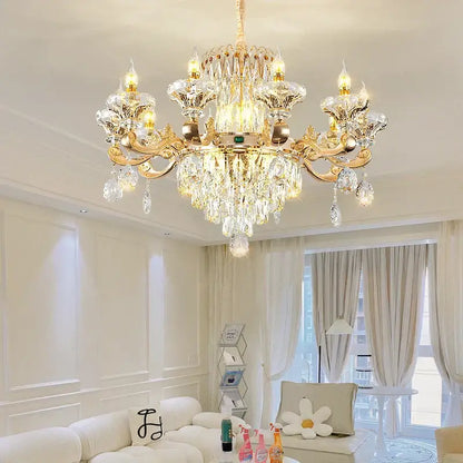 Gold-toned decorbites crystal chandelier with intricate crystal droplets and ornate arms lighting living spaces warmly