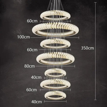 Modern multi-tiered decorbites crystal chandelier with frosted crystal rings and metallic accents for living and dining rooms
