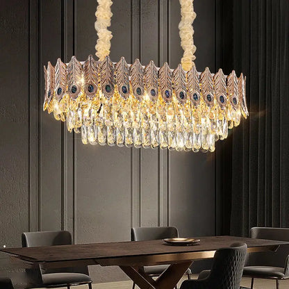 Gold-toned decorbites crystal chandelier shaped like a peacock feather with cascading crystals and dark blue gemstones