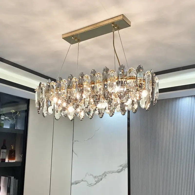 A modern decorbites crystal chandelier with gold metal frame and clear crystal teardrop pendants for elegant lighting