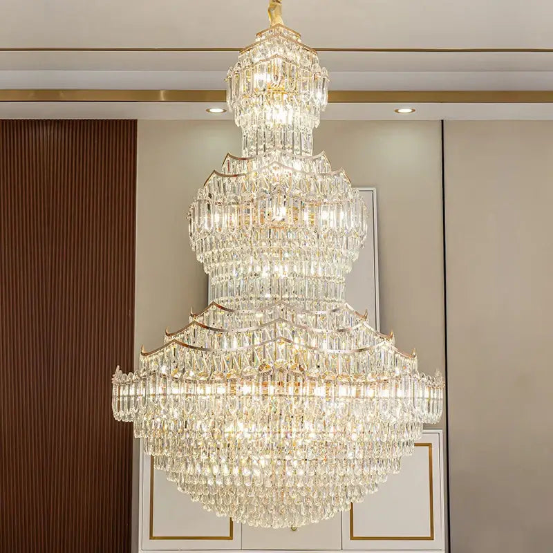 A multi-tiered decorbites crystal chandelier with gold-toned metal and clear glass prisms for European villa lobbies