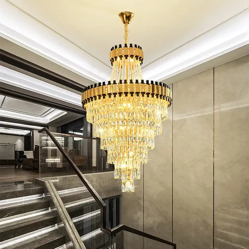 A multi-tiered decorbites crystal chandelier with golden metal frames and cascading clear prisms for luxury lighting