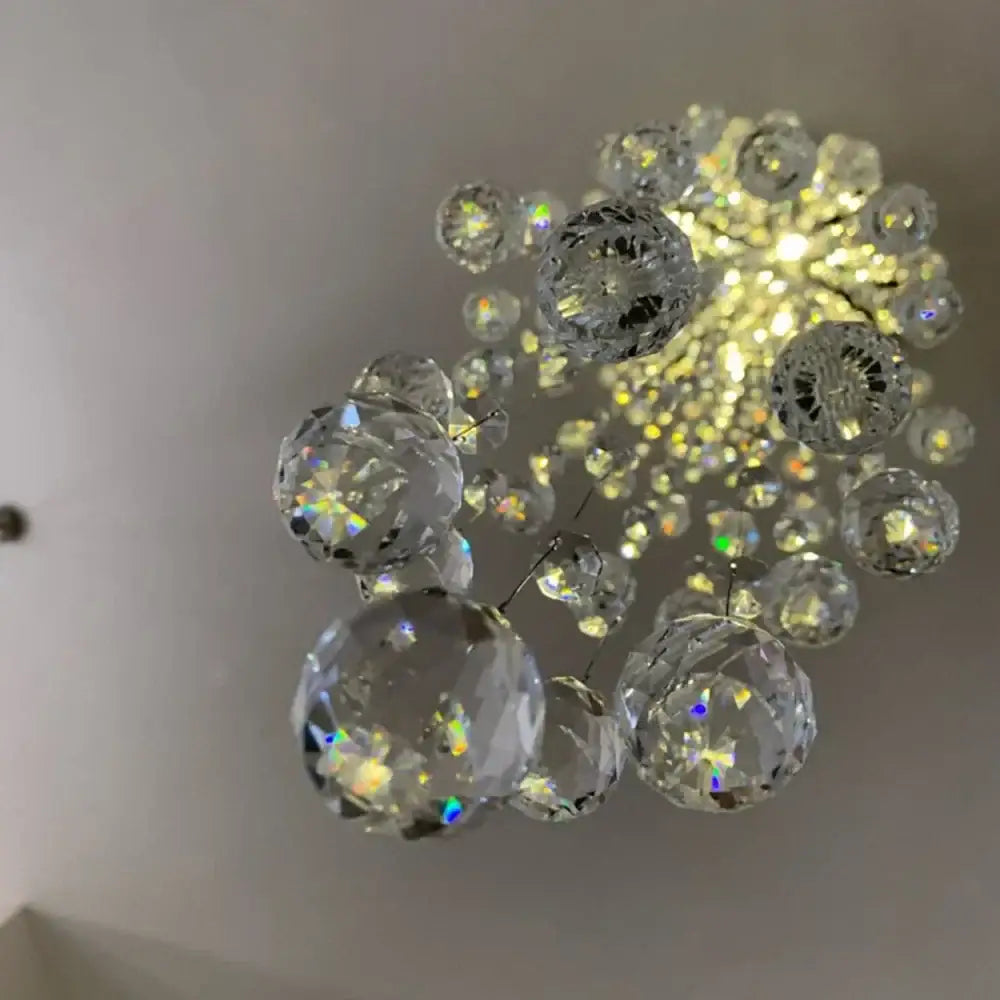 A decorbites crystal chandelier with clear faceted glass spheres in a starburst pattern for luxury hotel bedrooms